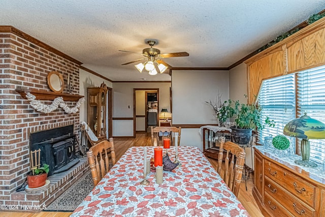 dining space featuring light hardwood / wood-style floors, a textured ceiling, and crown molding