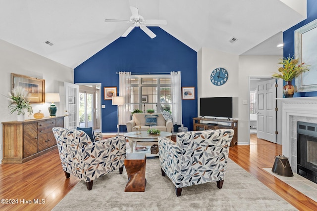 living room featuring ceiling fan, light hardwood / wood-style flooring, and lofted ceiling