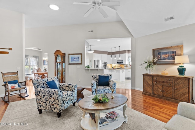 living room featuring light hardwood / wood-style flooring, ceiling fan, and lofted ceiling