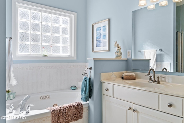 bathroom with vanity and tiled tub