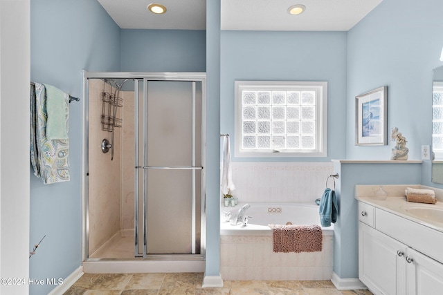 bathroom with vanity and shower with separate bathtub