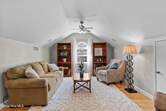 living room featuring ceiling fan, light hardwood / wood-style floors, and lofted ceiling