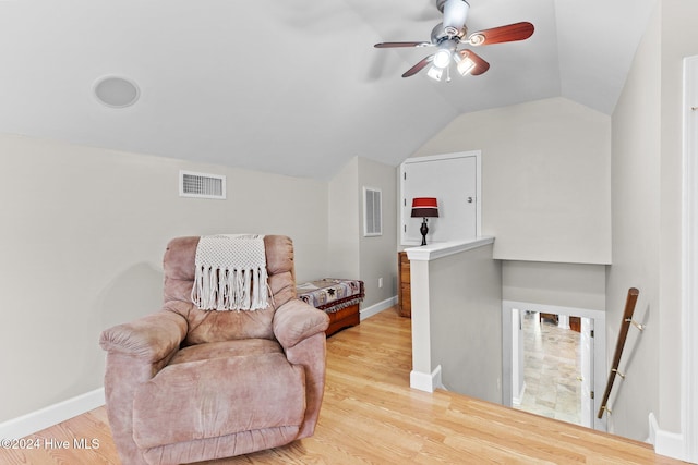 living area featuring lofted ceiling, ceiling fan, and light wood-type flooring