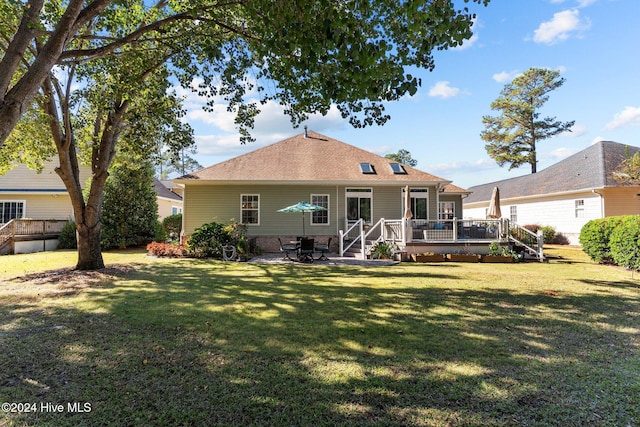 rear view of property with a lawn and a wooden deck