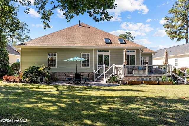 rear view of property with a patio area, a deck, and a yard