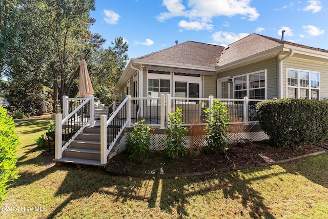 rear view of house featuring a yard and a wooden deck