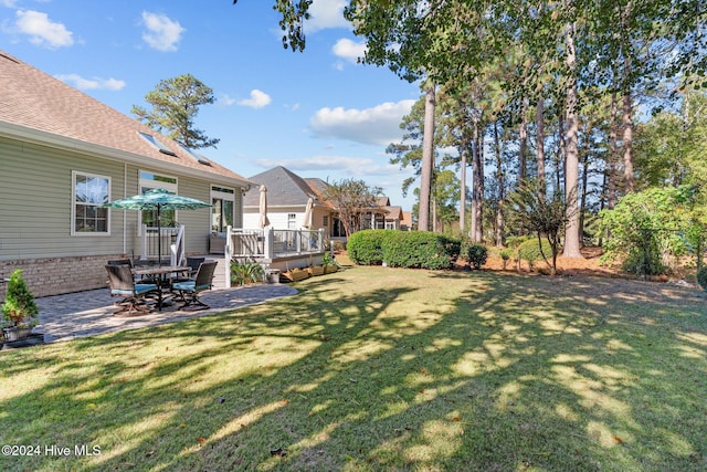 view of yard with a deck and a patio