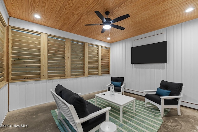 interior space with ceiling fan, wooden ceiling, a baseboard radiator, wood walls, and concrete flooring