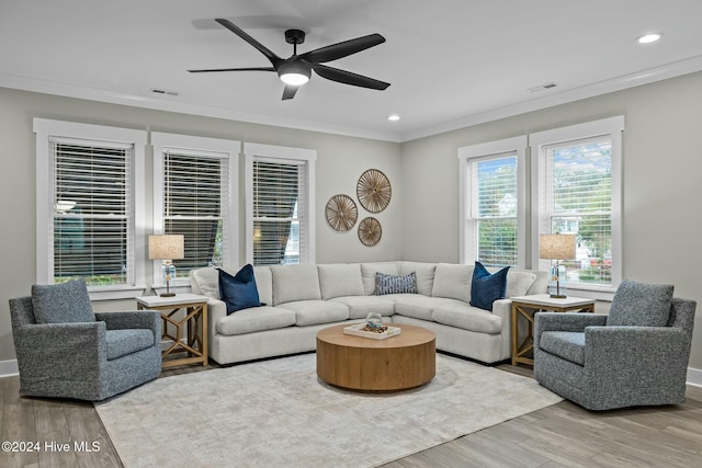 living room with ceiling fan, light wood-type flooring, and ornamental molding