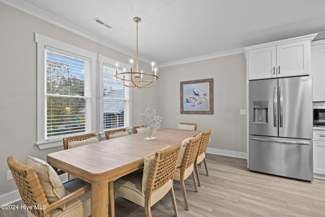 dining space with an inviting chandelier, ornamental molding, and light wood-type flooring