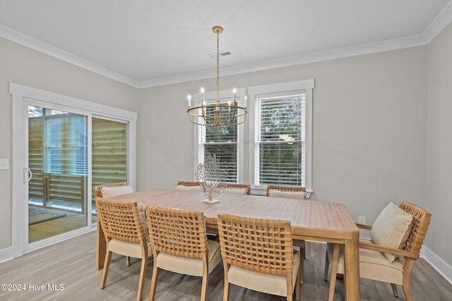 dining area featuring hardwood / wood-style flooring, ornamental molding, and a chandelier