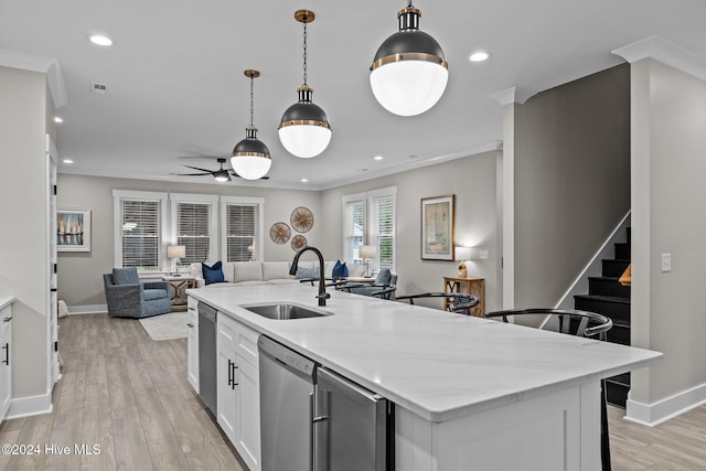 kitchen featuring light stone counters, stainless steel dishwasher, sink, light hardwood / wood-style flooring, and white cabinetry