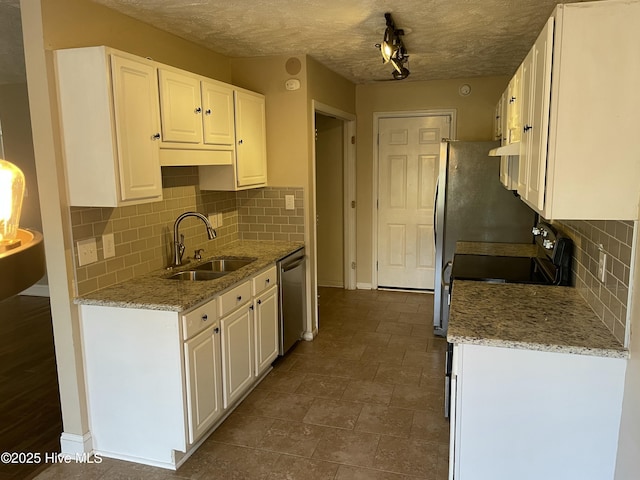 kitchen with backsplash, sink, stainless steel dishwasher, light stone counters, and white cabinetry