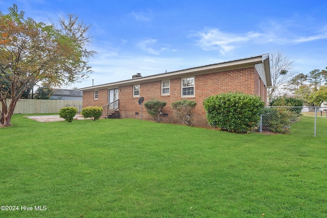 back of property featuring a lawn