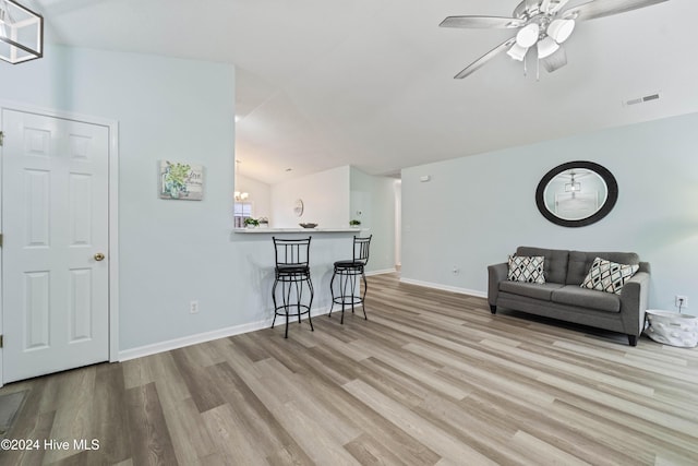 living room with ceiling fan, light hardwood / wood-style floors, and lofted ceiling