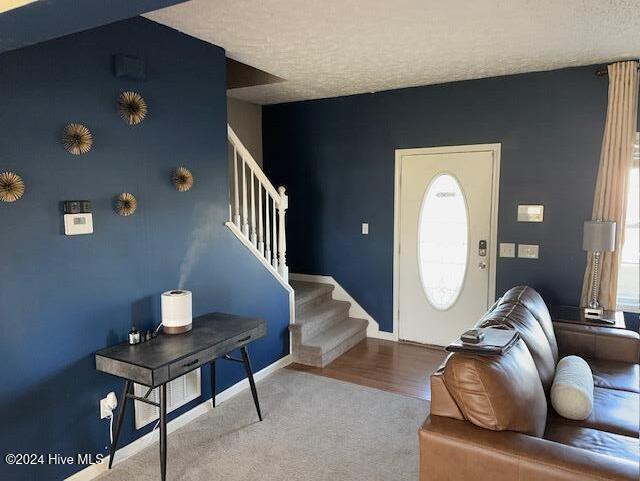 foyer entrance featuring hardwood / wood-style floors and a textured ceiling