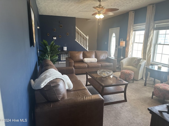 living room with ceiling fan, a textured ceiling, and carpet flooring