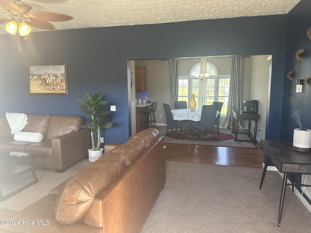 living room with a textured ceiling, hardwood / wood-style flooring, and ceiling fan