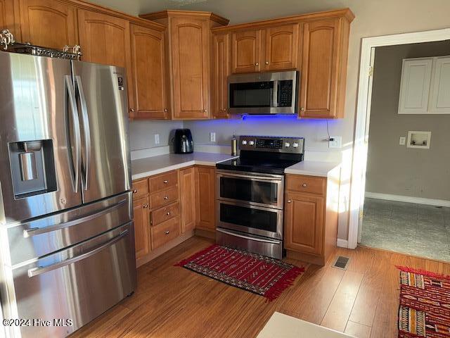 kitchen with stainless steel appliances and light hardwood / wood-style floors