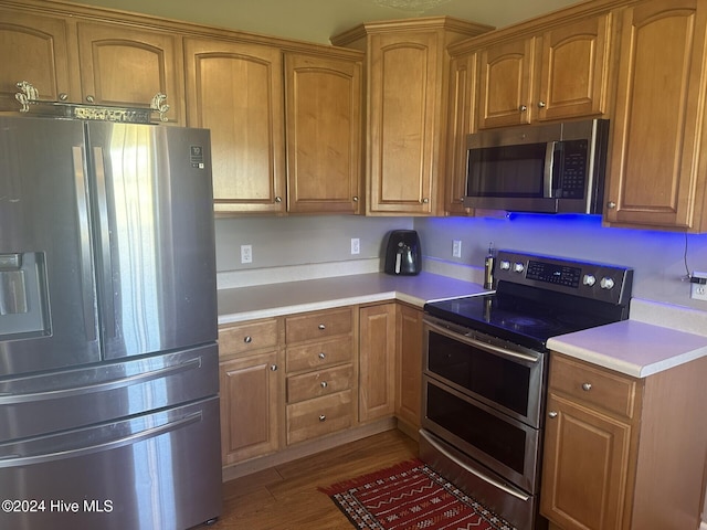 kitchen with hardwood / wood-style flooring and appliances with stainless steel finishes