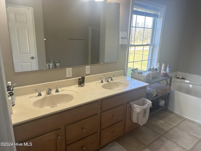 bathroom featuring a tub to relax in, vanity, and tile patterned flooring