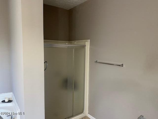 bathroom featuring a textured ceiling and an enclosed shower