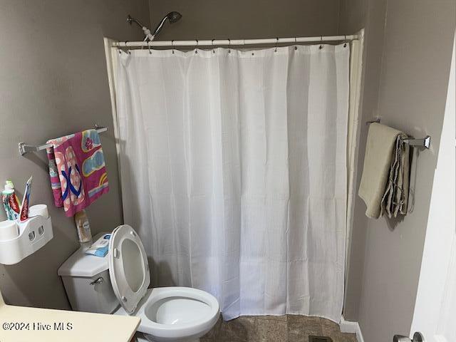 bathroom with toilet and curtained shower