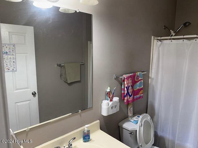 bathroom featuring curtained shower and toilet