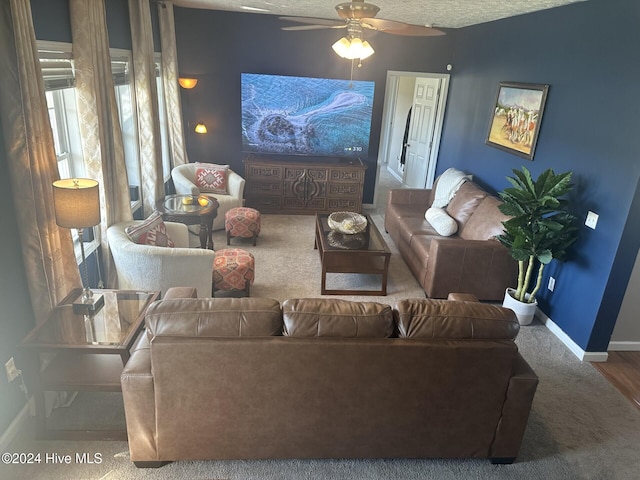 living room with hardwood / wood-style flooring, ceiling fan, and a textured ceiling