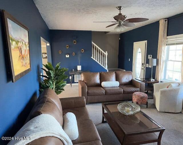 living room featuring ceiling fan, a textured ceiling, and carpet floors