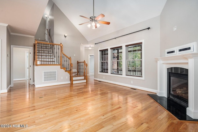 unfurnished living room with light hardwood / wood-style floors, ceiling fan, high vaulted ceiling, and ornamental molding