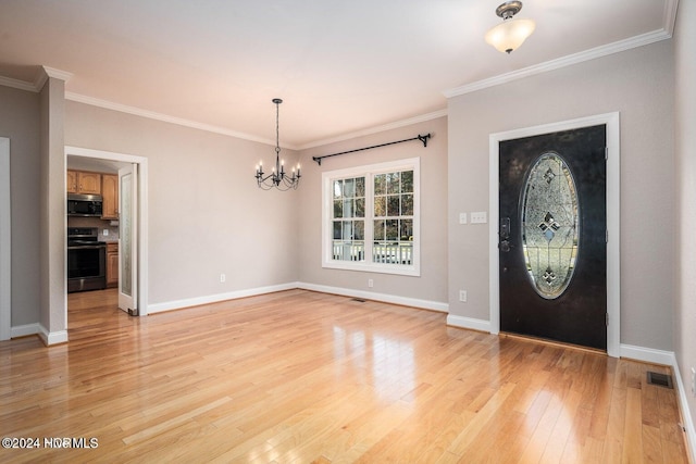 entrance foyer featuring light hardwood / wood-style floors, an inviting chandelier, and crown molding