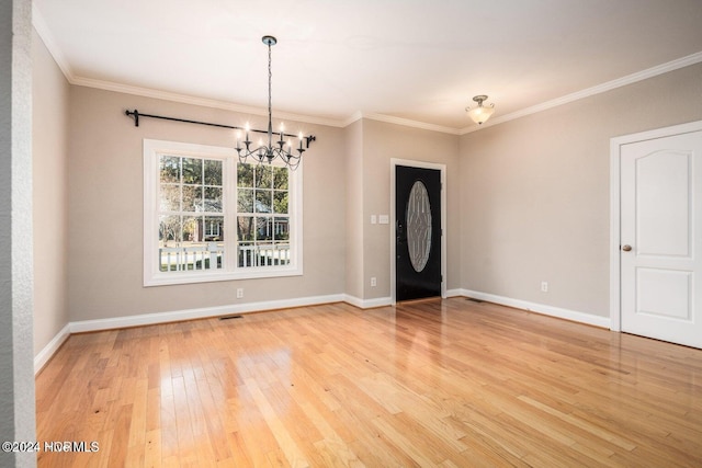 foyer featuring a notable chandelier, hardwood / wood-style flooring, and crown molding