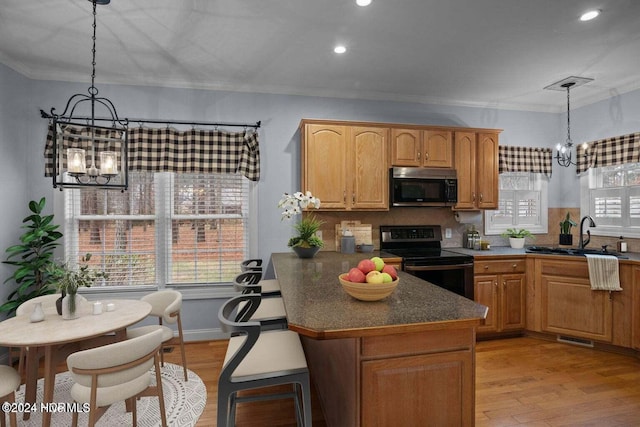 kitchen with an inviting chandelier, plenty of natural light, decorative light fixtures, and appliances with stainless steel finishes