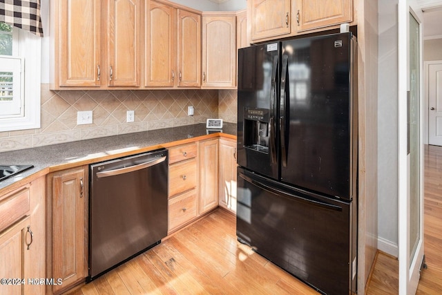 kitchen with black fridge, dishwasher, decorative backsplash, light brown cabinets, and light wood-type flooring