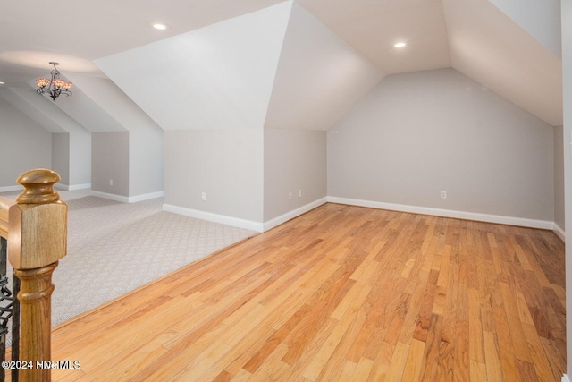 additional living space with lofted ceiling and light hardwood / wood-style flooring