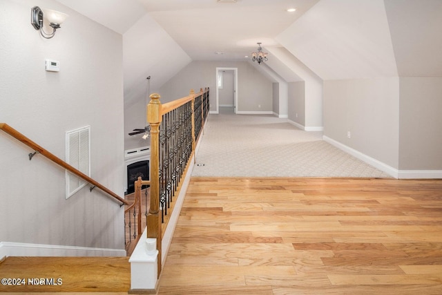 interior space with carpet, a fireplace, vaulted ceiling, and an inviting chandelier