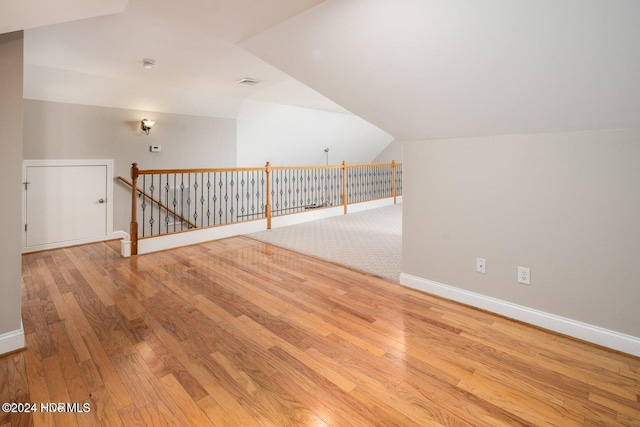 bonus room with light wood-type flooring and lofted ceiling