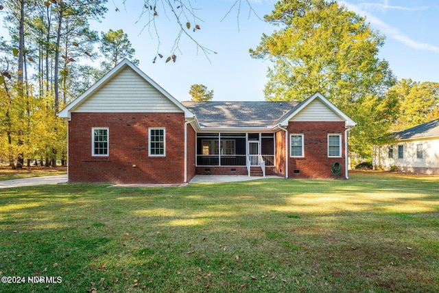 rear view of house featuring a sunroom and a lawn