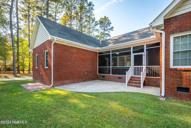 back of property with a lawn, a patio, and a sunroom