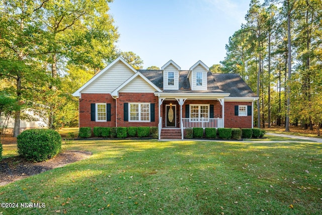 cape cod home with a front yard and covered porch