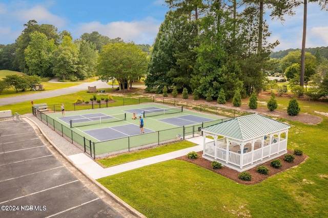 view of tennis court featuring a lawn and a gazebo