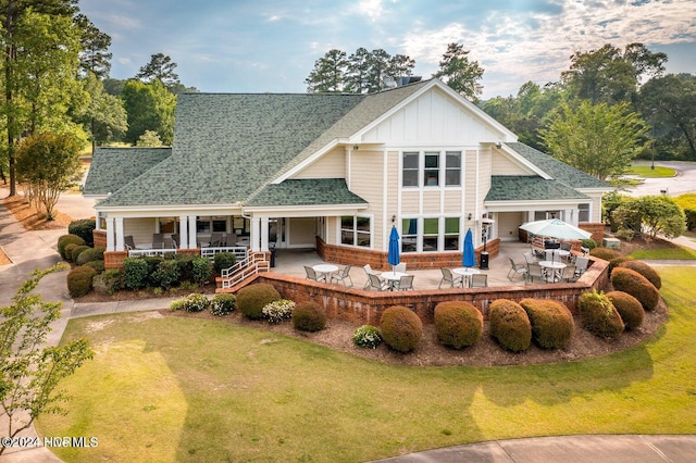 rear view of house featuring a yard and covered porch