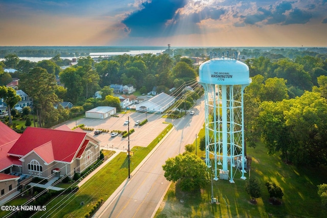 aerial view at dusk featuring a water view