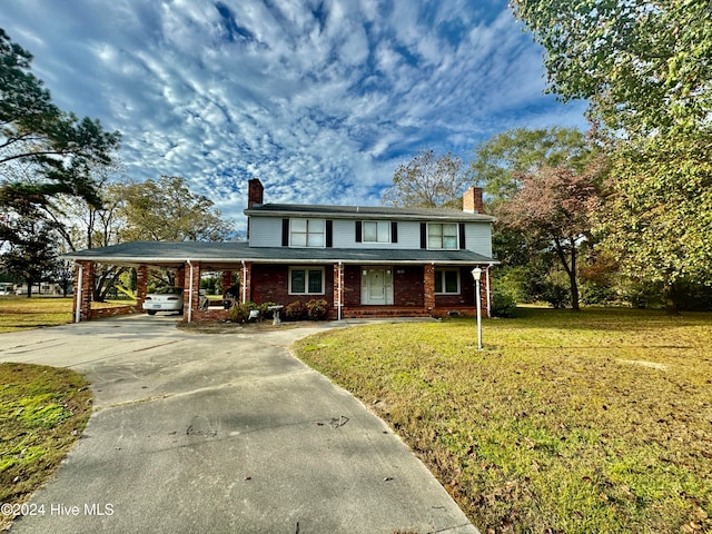 view of front of house featuring a front lawn and a carport