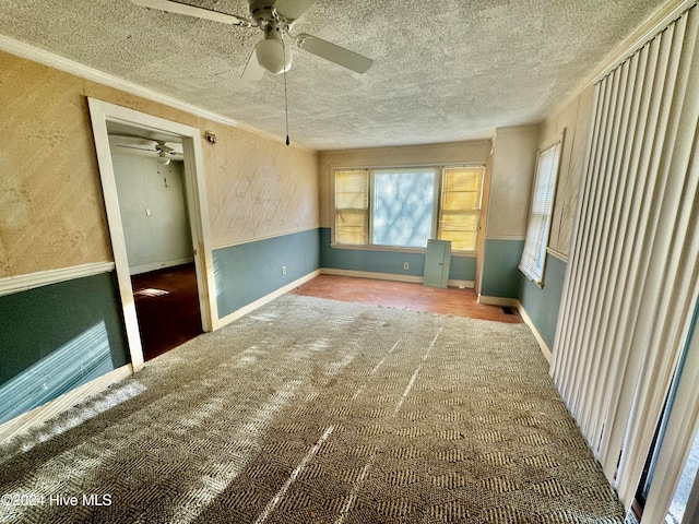 unfurnished room featuring ceiling fan, a textured ceiling, crown molding, and carpet floors