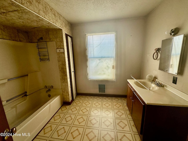 bathroom with vanity, a textured ceiling, and washtub / shower combination