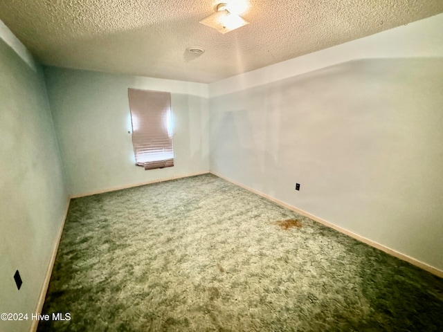 carpeted spare room featuring a textured ceiling