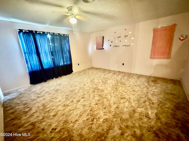 carpeted spare room with a textured ceiling and ceiling fan