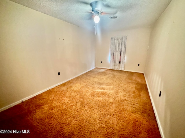 carpeted spare room featuring ceiling fan and a textured ceiling